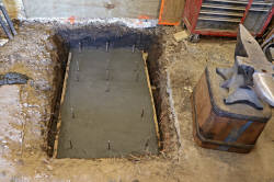 Finished concrete foundation pad for new stone forge