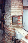 Hearth plate rests on corbelled shelves on the lower sides of chimney.